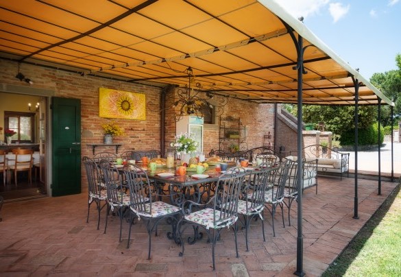 La zona pranzo esterna, allestita con tavolo, sedie e piano cottura - Casale dei Girasoli