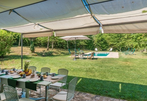 The equipped pergola furnished with tables, chairs, and loungers - Casale dei Tigli