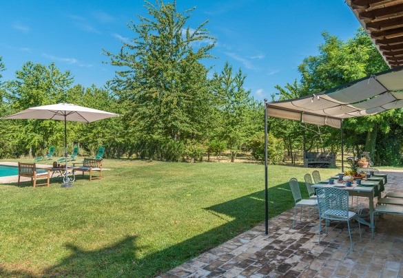 The equipped pergola furnished with tables, chairs, and loungers - Casale dei Tigli