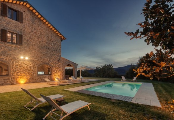 La piscina avvolta da luci dai toni caldi e soffusi – Casale del Castagneto
