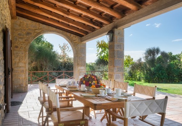 Il portico ombreggia il tavolo preparato per colazioni all’aperto – Casale del Castagneto