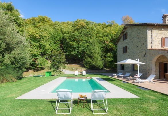 Il solarium in travertino circondato dal prato curato – Casale del Castagneto
