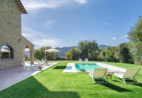 Il solarium in travertino circondato dal prato curato – Casale del Castagneto