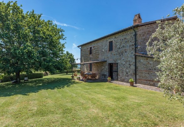 La pergola sul retro vicino alla cucina è attrezzata con tavolo da pranzo, più distante verso la siepe che delimita il confine si trova il barbecue in muratura- Casale del Viaggiatore