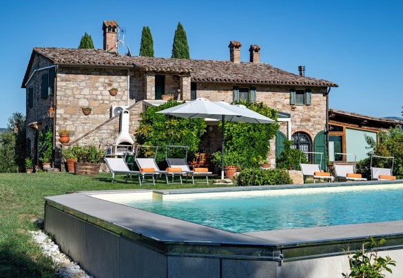 The swimming pool and the main house in the background - Casale delle Farfalle