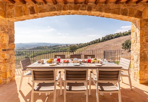 Il porticato arredato con tavoli e sedie per mangiare all’aperto - Casale Grottini