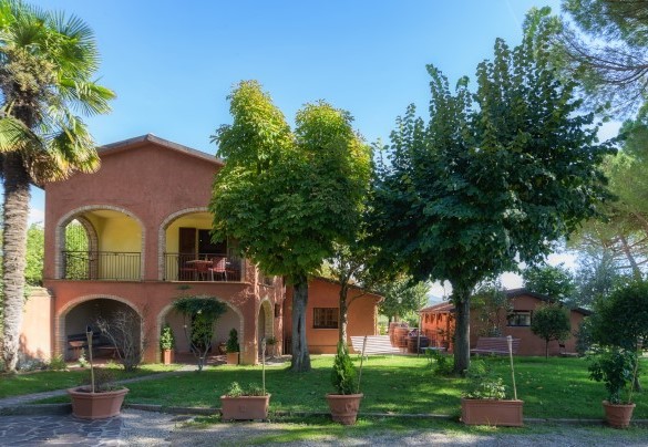 Il casale dipinto di rosso ocra e il parco che lo circonda - Casale Il Torchio 