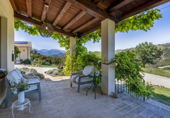 Il porticato all'uscita della casa ospita un salotto all'aperto - Casale La Cascina 