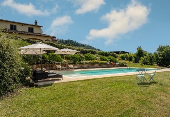 The pool immersed in the green garden with the equipped sunbath area – Casale Le Conce