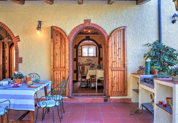 The porch shades the table prepared for outdoor breakfast – CasaLe Conce 