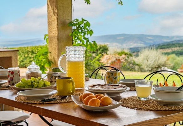 The porch shades the table prepared for outdoor breakfast – Casale Le Conce 