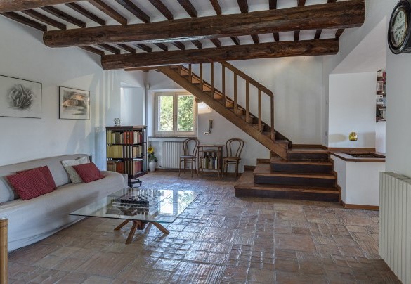 Il salotto con Smart TV, caminetto ornamentale e scala per il primo piano - Casale Le Querce di Cetona