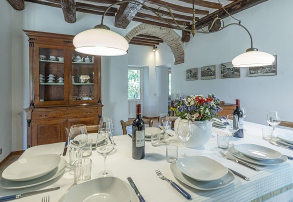 La cucina con tavolo da pranzo collegata al salotto e l’ingresso secondario lato parcheggio interno scoperto - Casale Le Querce di Cetona