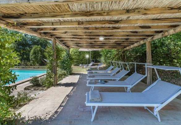Il solarium in cotto e prato ospita una pergola, lettini, due ombrelloni e un’amaca - Casale Le Querce di Cetona