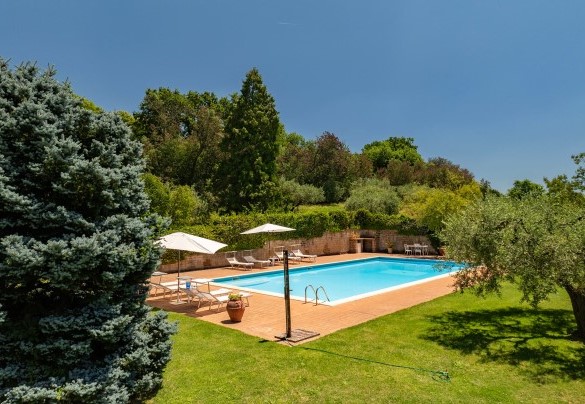 La piscina ha solarium in pietra con lettini, ombrelloni e doccia fredda – Casale Le Querce 