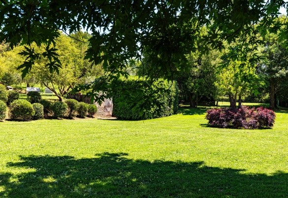 Il giardino verde e curato tra la villa e la piscina – Casale Le Querce