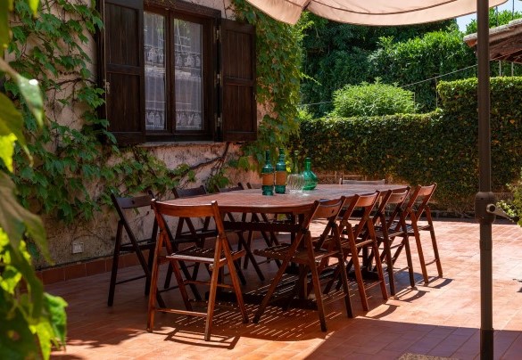 La corte con tavolo da pranzo e barbecue in muratura, all’uscita della sala da pranzo – Casale Le Querce 