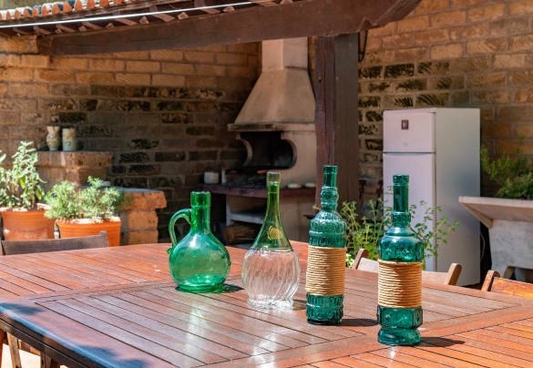 La corte con tavolo da pranzo e barbecue in muratura, all’uscita della sala da pranzo – Casale Le Querce