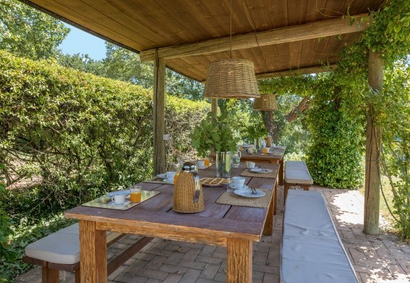 The wooden pergola shelters outdoor dining tables - Casale Piattini