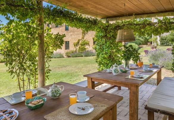 The wooden pergola shelters outdoor dining tables - Casale Piattini