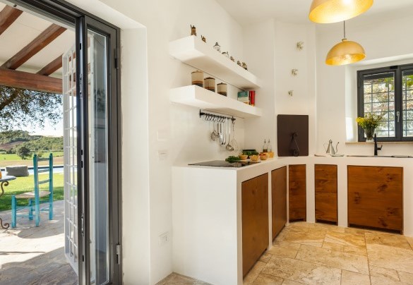 La cucina in muratura con lavanderia e uscita in giardino - Casale Rondinella