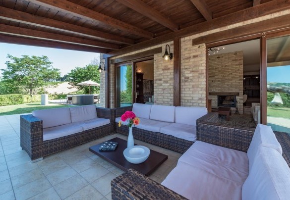Elegant panoramic lounge equipped with a table and sofas under a wooden pergola - Casale Rosy 6+2
