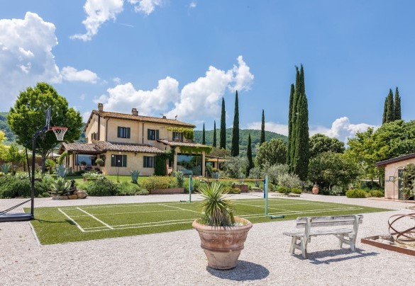 The badminton court (also equipped with two basketball hoops) and the house in the background - Casale Santa Lucia