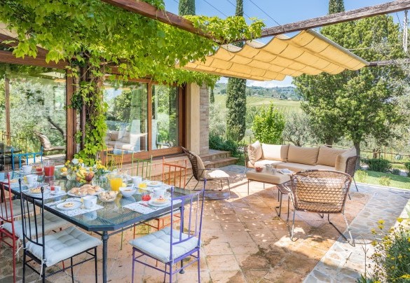 Under the pergola is a dining area furnished with tables, chairs, sofa and armchairs - Casale Santa Lucia  