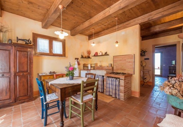 Piccolo soggiorno con cucina dell'appartamento al piano terra e dettaglio della camera matrimoniale n.2 - Casale Verdicchio 10+2