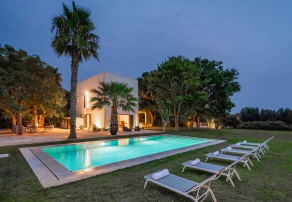 Vista della piscina e della villa illuminate di sera - Casavento Puzzitteddu