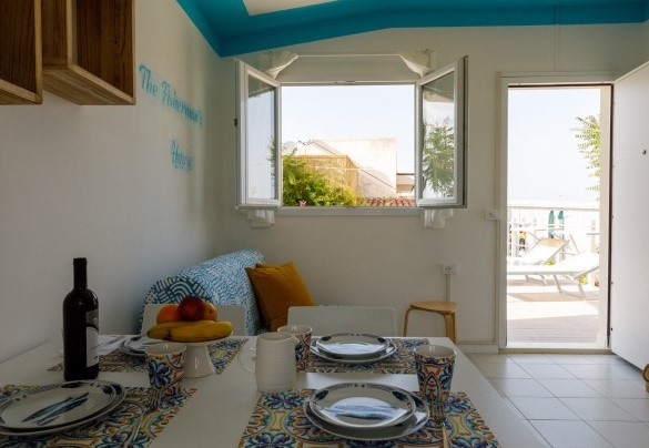 Tavolo da pranzo e un divanetto nel piccolo living – Casetta del Pescatore