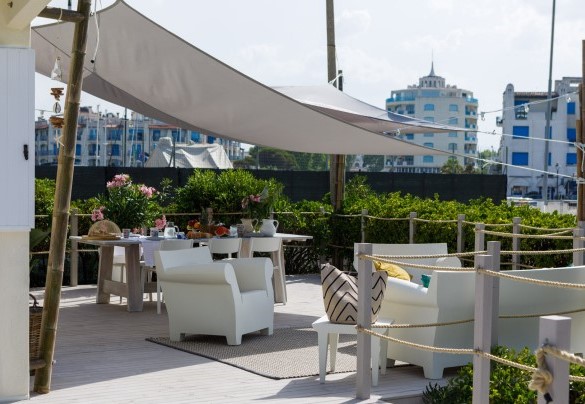 La casa è abbracciata da una banchina rialzata in legno naturale dove si trova la zona solarium e relax con lettini, una grande tavola da pranzo, divano, poltrone – Casetta del Pescatore