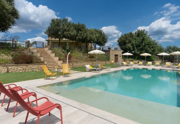 La piscina si raggiunge tramite un comodo vialetto nel prato che porta al cancello di ingresso, scendendo poi la scala in pietra – Casolare San Martino