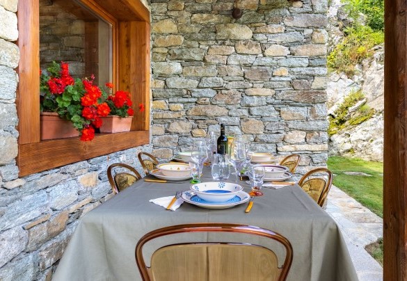 Sotto al patio che è attrezzato con tavole e sedie per consumare i pasti all’aperto, dalla prima colazione alla cena - Chalet Walser