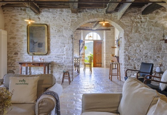 Main entrance of the stone house with brick arch and exposed beam ceilings - Checello