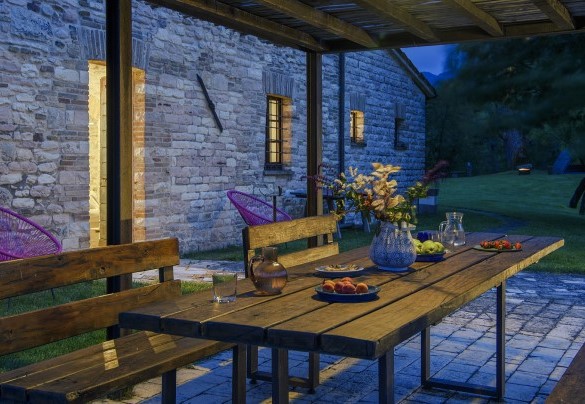 Wooden table set under the gazebo in the evening hours - Checello