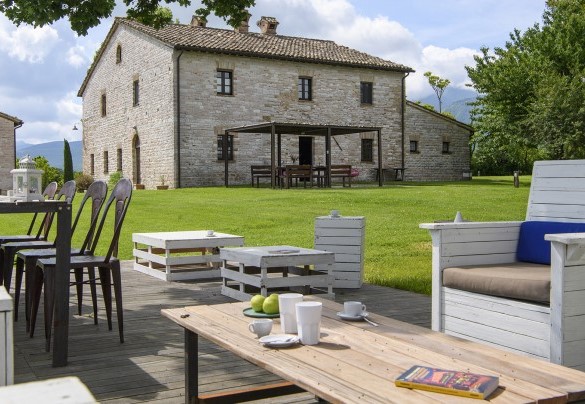 Wooden terrace with outdoor furniture and garden view - Checello