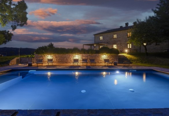 Pool lit up with the villa in the background during evening hours - Checello
