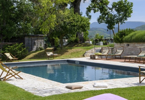 Pool area surrounded by greenery with loungers along the edges - Checello
