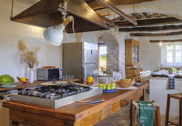 Equipped kitchen facing the dining room, with exposed beams - Checello