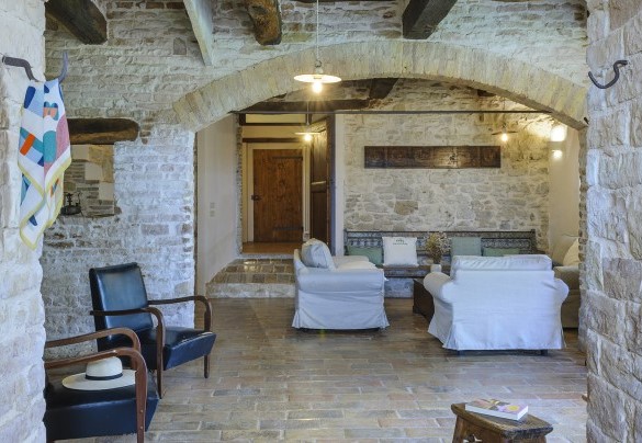 Lounge with wooden beam ceilings, comfortable seating, and decorated bench - Checello