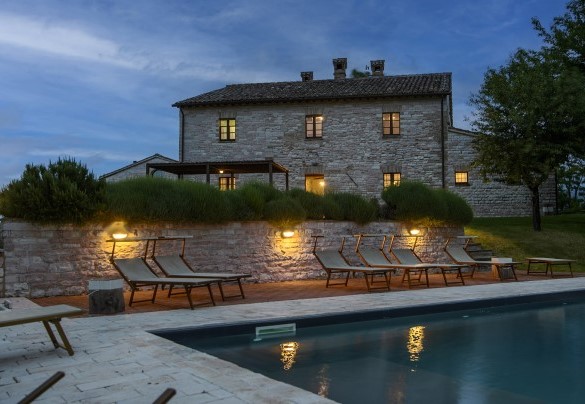 Evening view of the lit pool and stone house in the background - Checello