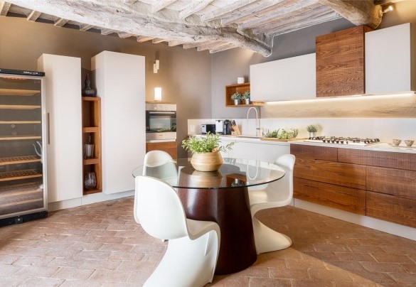 The kitchen is connected through a French window to the pergola with dining table – Cinque Cipressi