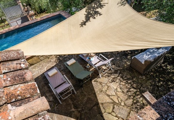 Il solarium in pietra attrezzato con lettini e vela ombreggiante - Colle Calzolaro  