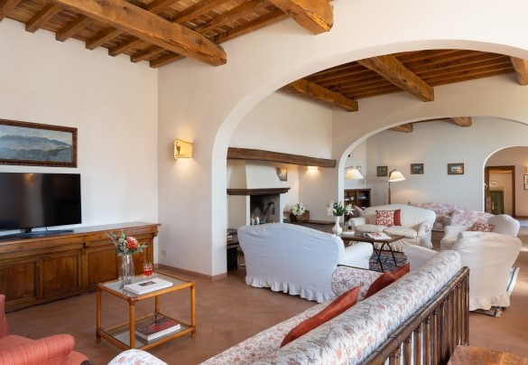 The large living room, with access to the outside through a French window, with fireplace and TV – Cosciano