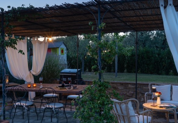 La bella pergola avvinta da gelsomini, arredata con area salotto, tavolo per pranzare e barbecue – Country House Lo Spigo