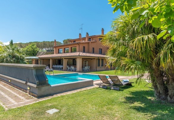 The pool immersed in the green garden and the house in the back ground – Montepietraia – Country House Montepietraia e San Martino 