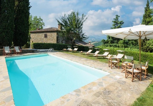 View of the pool and the solarium furnished with sun beds, umbrella, and living area – Crognole 