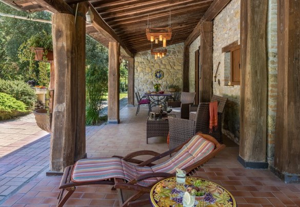 The large portico adjacent to the house furnished with a big table, chairs, sofa and armchairs - Dimora Alessandra 