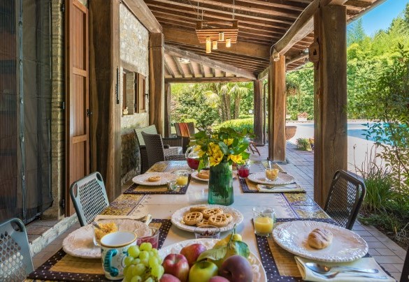 The outdoor dining area under the portico, set up with table and chairs - Dimora Alessandra 